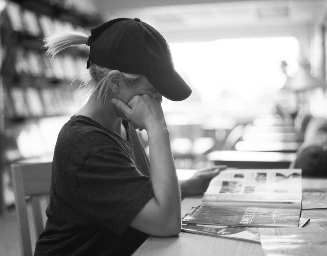 A person with a worried or anxious expression sitting at a desk.