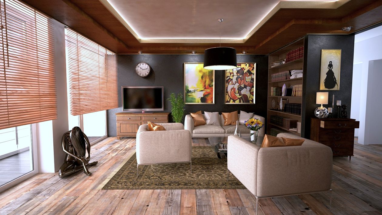 A person uses a tablet in a clean, modern living room, symbolizing the use of technology and innovation in modern real estate.