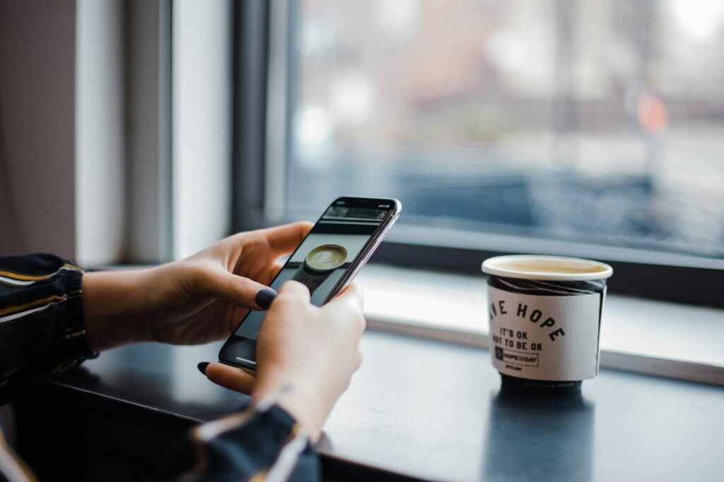 Person holds a smartphone displaying a modern budgeting or finance application, representing tech-forward solutions for sa...